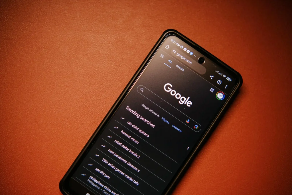 Smartphone displaying Google search homepage with trending searches on screen