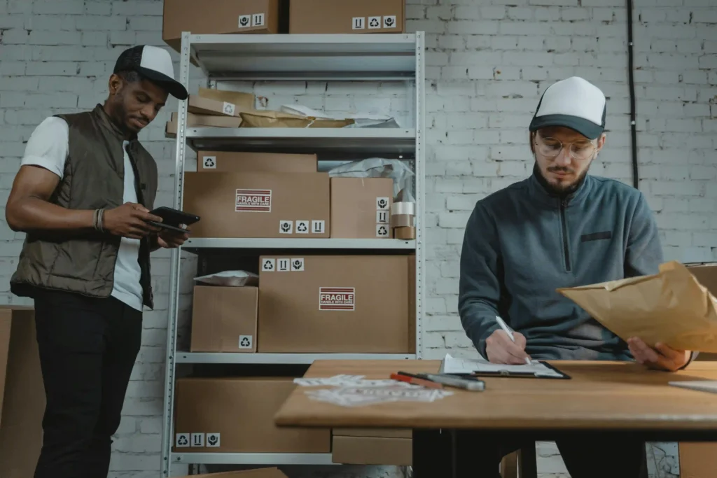 two workers are filling the details of the customers on their ordered products