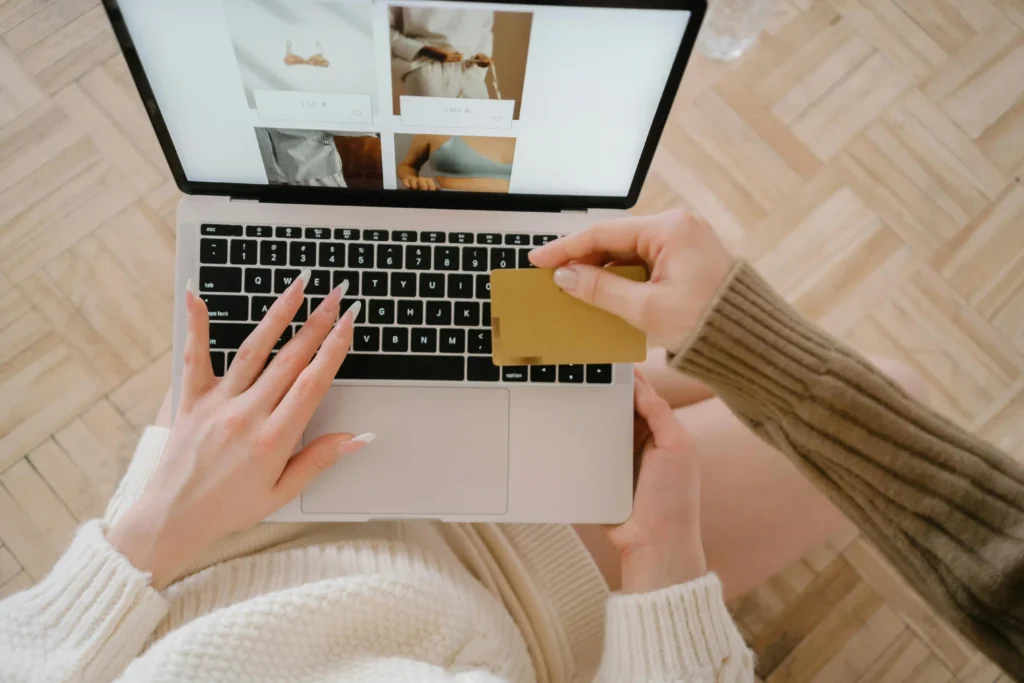 Person entering credit card details on laptop while shopping online